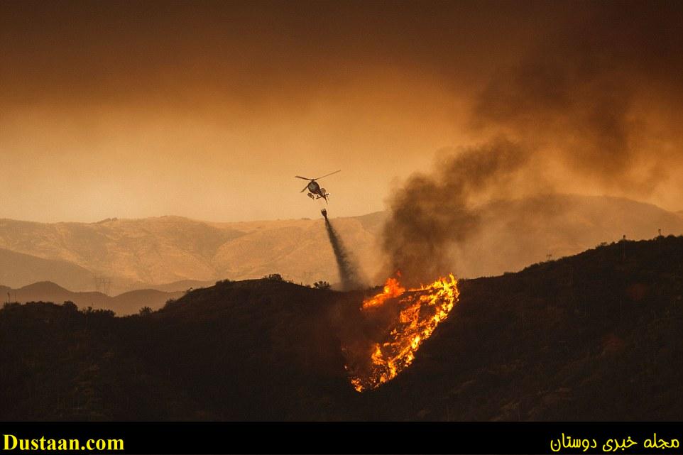 A firefighting helicopter drops water at the Sand Fire near Santa Clarita, California, on Saturday which has been fueled by temperatures reaching about 108 degrees fahrenheit