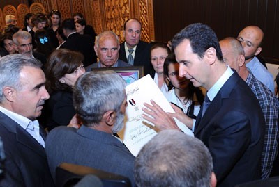 اسد و همسرش درکنار خانواده‌های کشته‌شدگان + عکس
