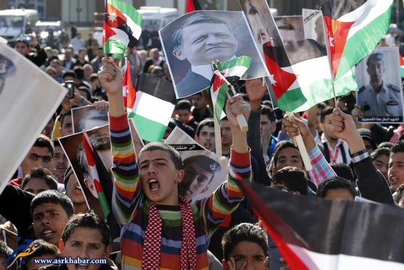 Protesters hold up pictures of Jordan's King Abdullah and pilot Muath al-Kasaesbeh as they chant slogans during a rally in Amman
