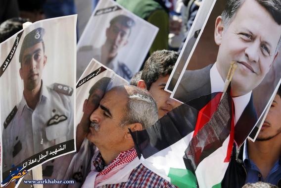 A Jordanian protester kisses a poster bearing the image of Jordanian pilot Muath al-Kasaesbeh during a rally to show their loyalty to King Abdullah and against the Islamic State in Amman