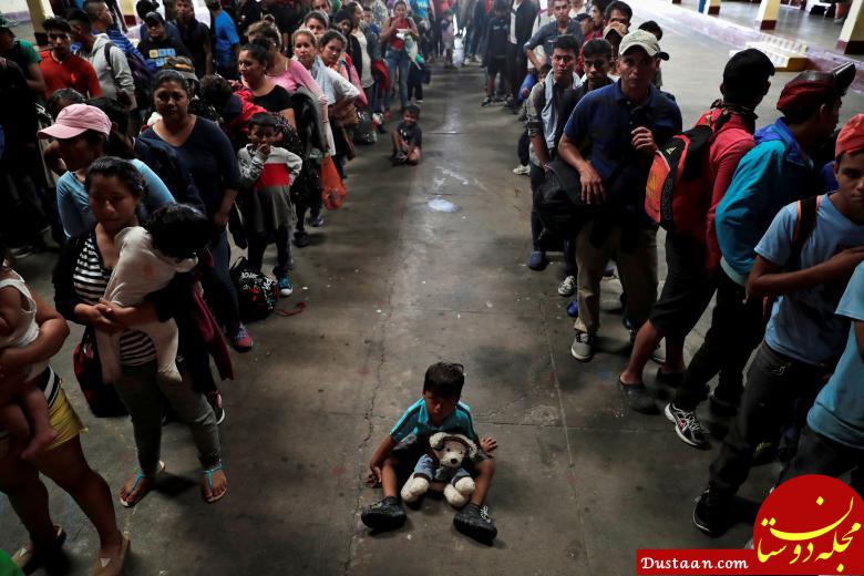 یک کودک در میان مهاجران هندوراسی که سعی دارند به آمریکا بروند، بر روی زمین نشسته است